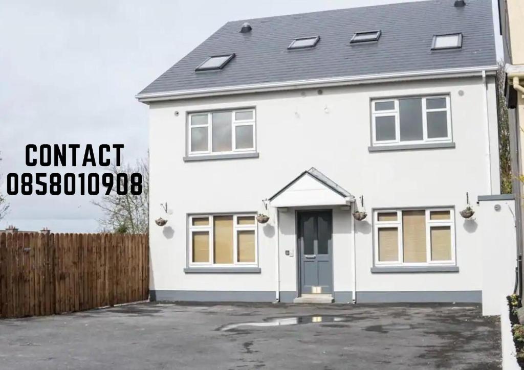 una casa blanca con un letrero que lee osteosclerosis de contacto en Waterlane, en Galway