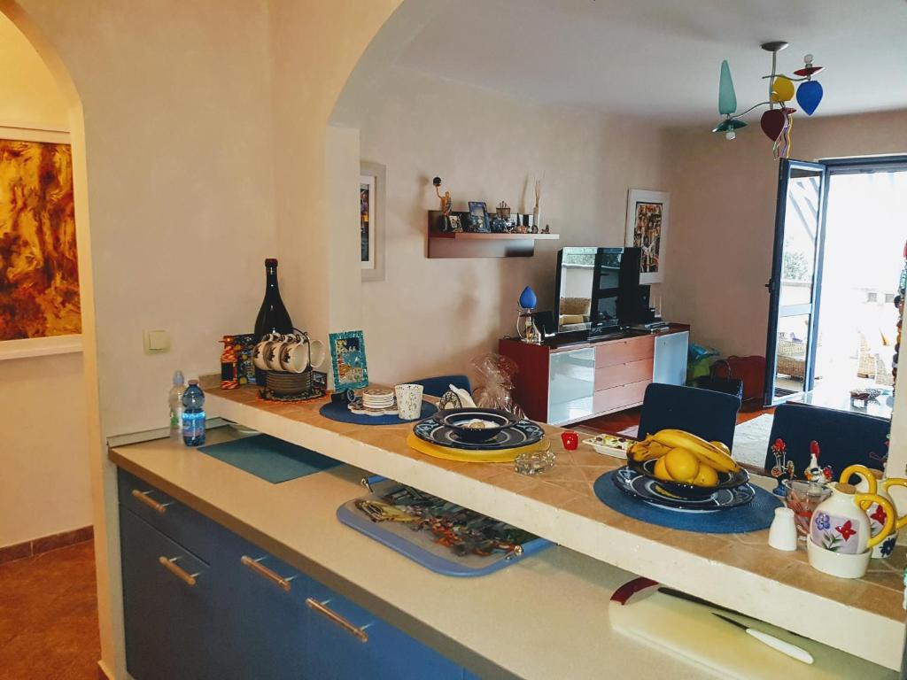 a kitchen with a counter with plates and bananas on it at Apartman Azzuro in Pržno