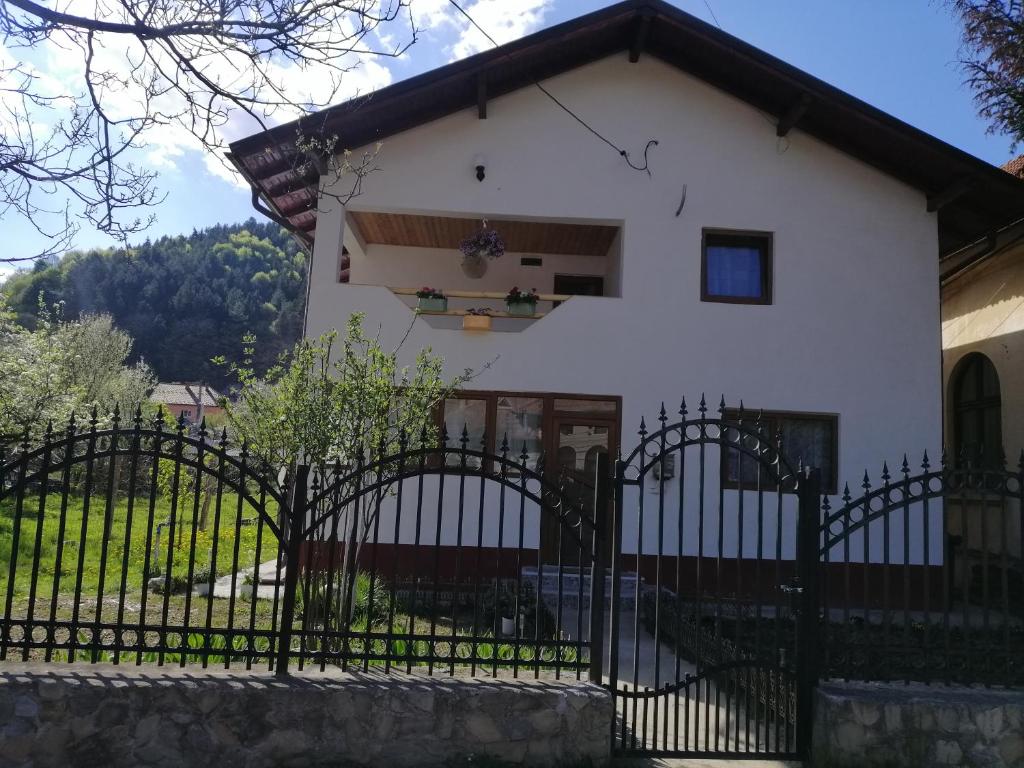 a white house with a black fence at CASA MADAME COCO in Piatra