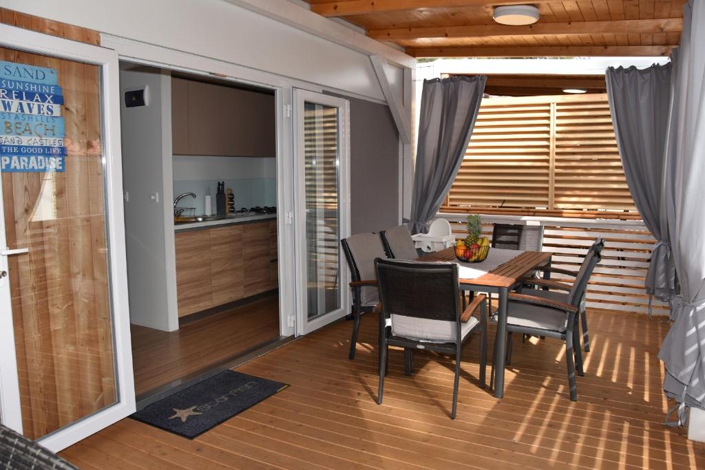 uma cozinha e sala de jantar com mesa e cadeiras em Mobile Home Starfish I Camp Soline em Biograd na Moru