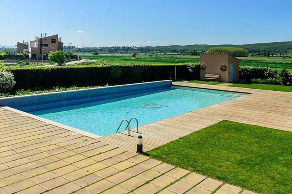 una piscina en un patio con terraza de madera en Idílico Dúplex en la costa brava, con piscina, en Albóns