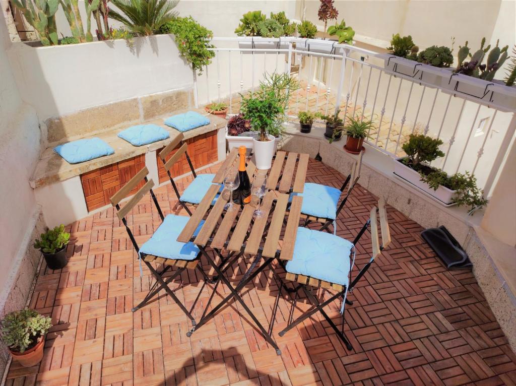 una mesa y sillas en un balcón con plantas en Suite Bagnara- Ortigia Holidays, en Siracusa