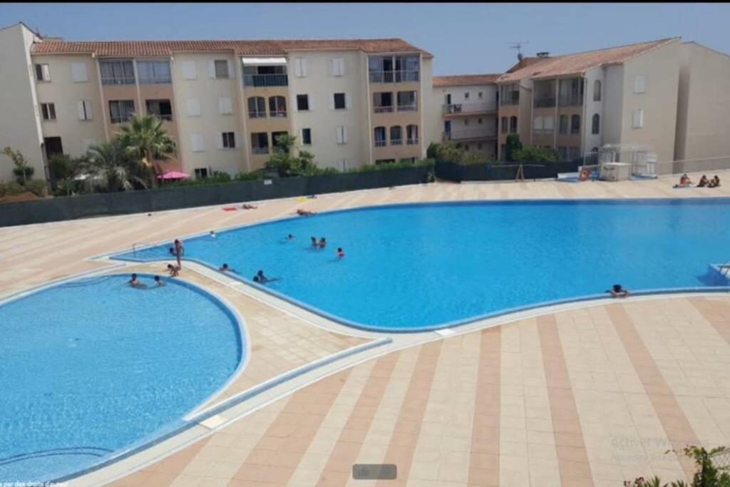 een groot zwembad voor sommige appartementsgebouwen bij Appartement très agréable in Fréjus