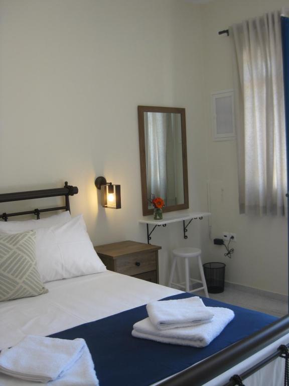 a bedroom with a bed with towels on it at RESTIA in Agios Petros