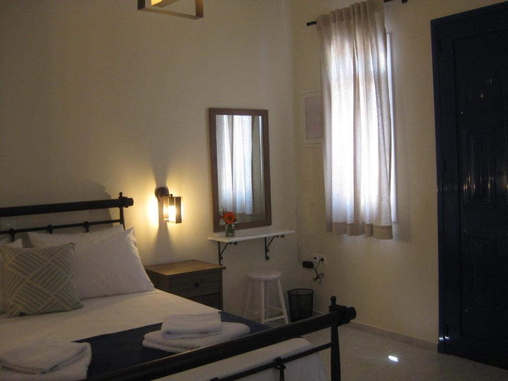 a bedroom with a bed and a mirror and a window at RESTIA in Agios Petros