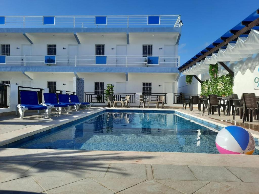 einem Pool mit Stühlen und einem Ball vor einem Gebäude in der Unterkunft Costa Love Aparta Hotel in Punta Cana
