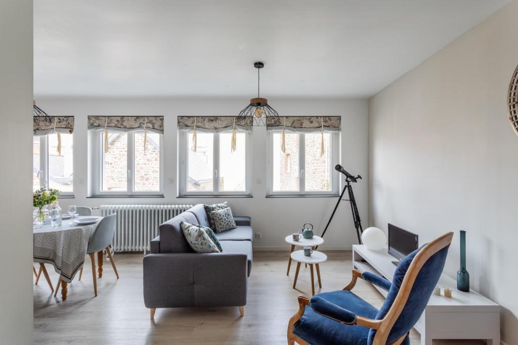 a living room with a couch and a table at Les Abîmes, beau logement avec 2 chambres avec parking in Saint Malo