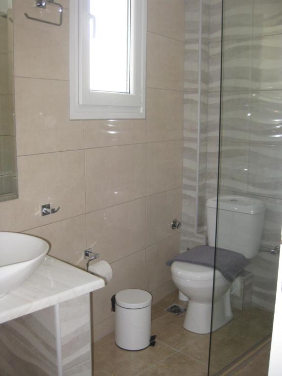 a bathroom with a toilet and a sink at RESTIA in Agios Petros