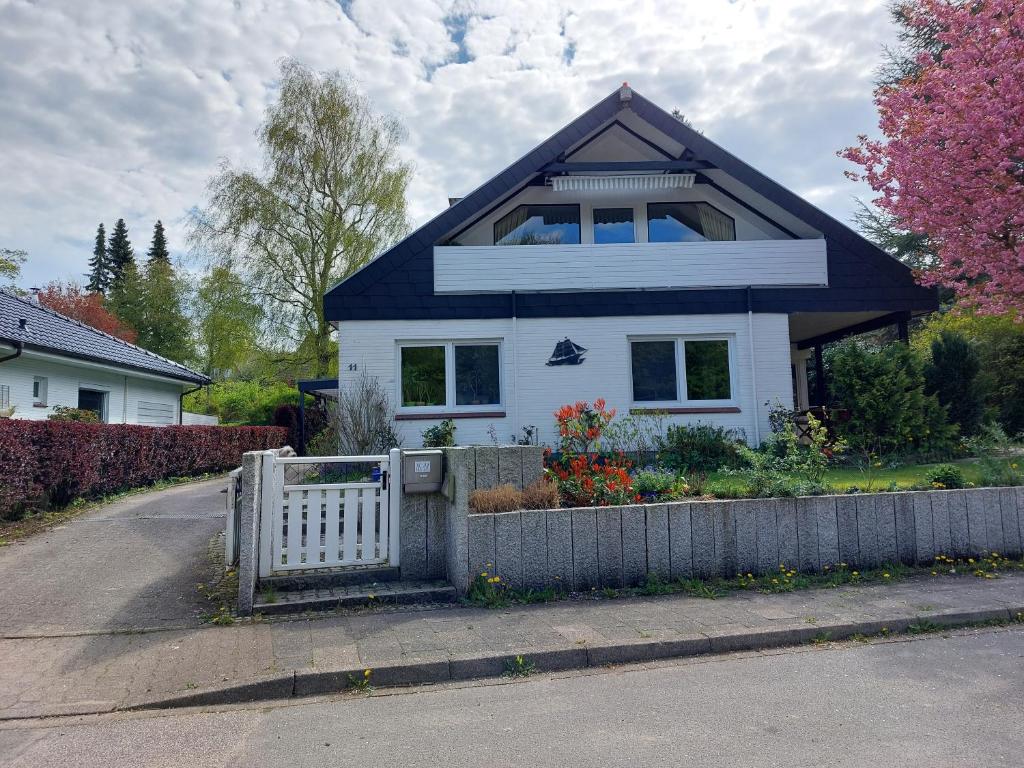 uma casa branca com uma cerca à frente. em Haus Finisberg em Flensburg