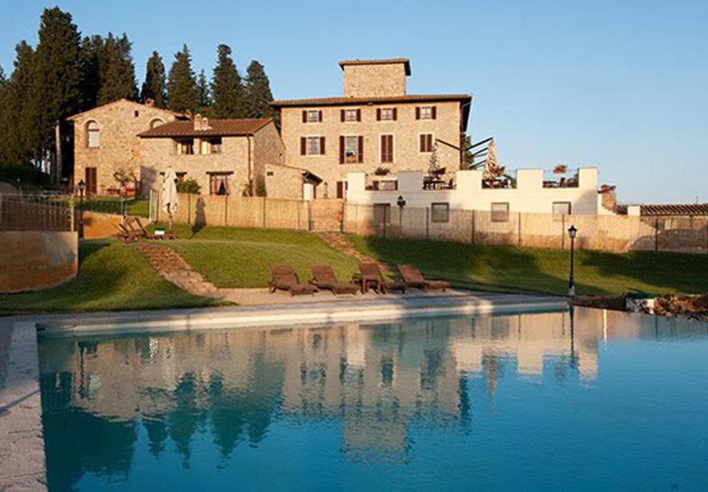 une grande maison avec une piscine en face de celle-ci dans l'établissement Villa San Filippo, à Barberino di Val dʼElsa