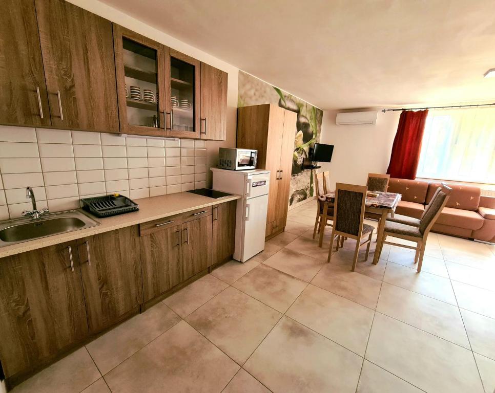 uma cozinha com armários de madeira e uma mesa com cadeiras em Anita Apartman Sopron em Sopron