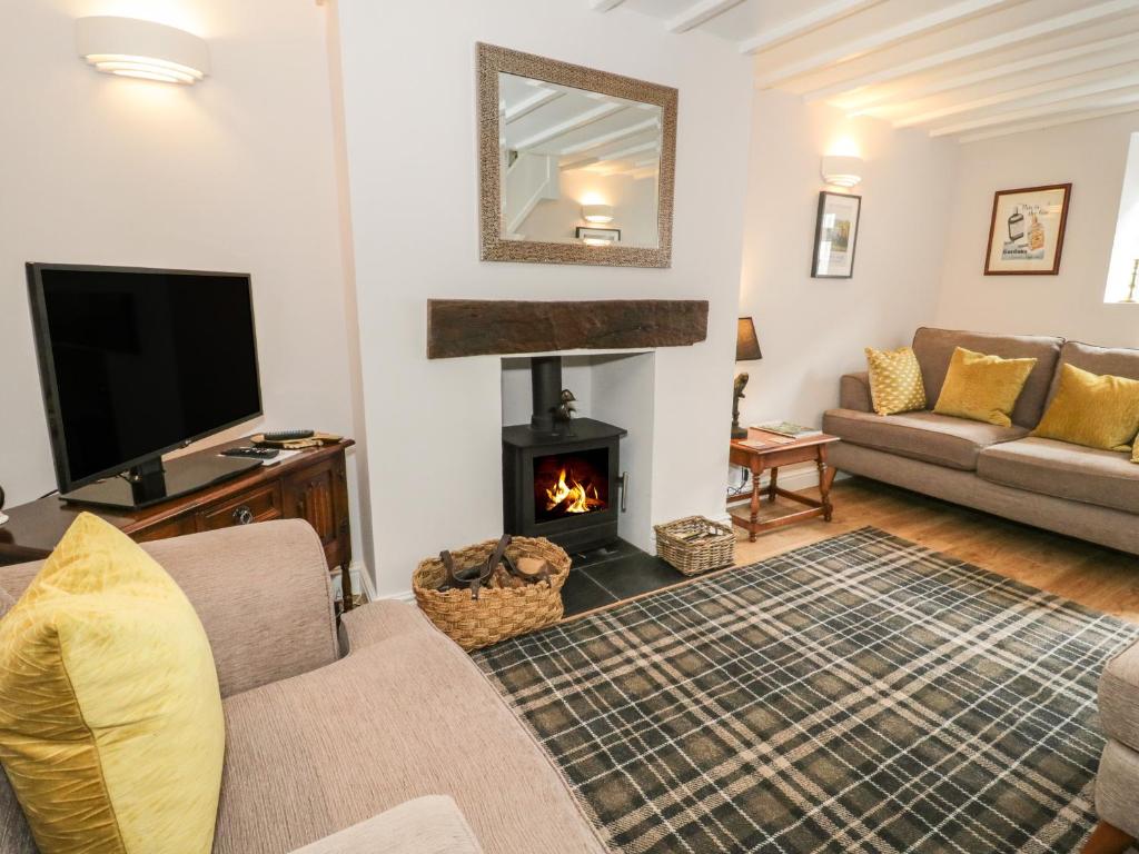 sala de estar con chimenea y sofá en Marlin Cottage en Conwy