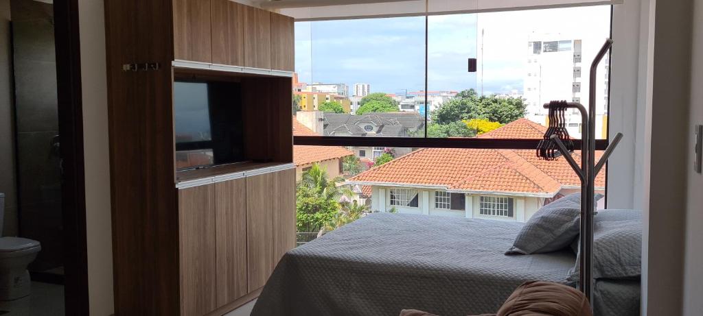 a bedroom with a bed and a window with a view at Práctico Smart Studio in Santa Cruz de la Sierra