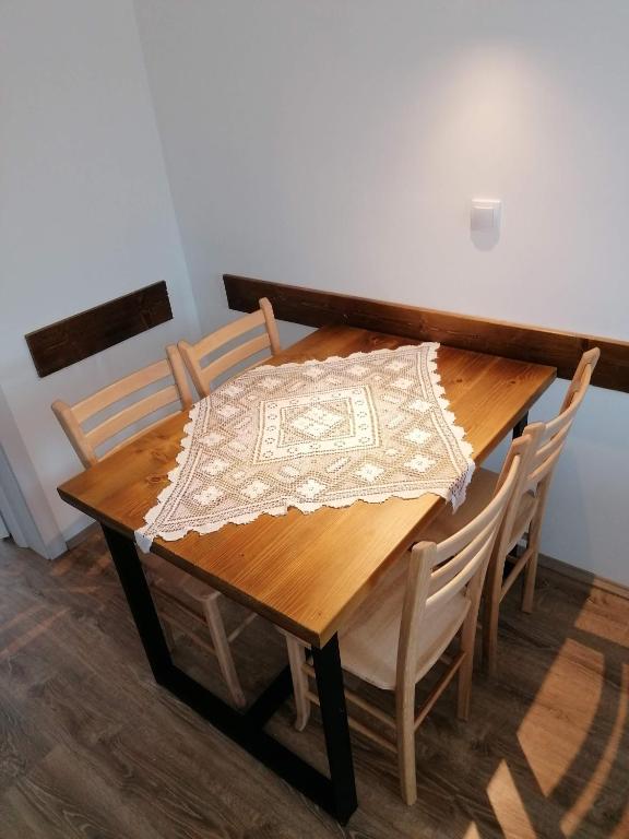a wooden table with chairs and a table cloth on it at Nikolića kuća in Mitrovac