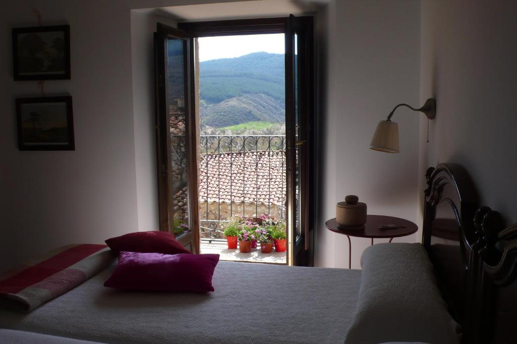 a bedroom with a bed and a window with a view at Casa La Rinconada in Azuelo