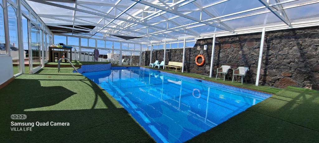 a large swimming pool in a large building at Villa Life in Güime