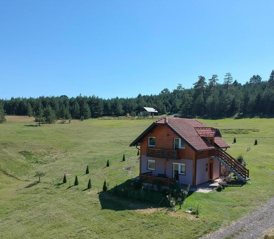 a small house in the middle of a field at Vikendica Studenac in Zlatibor