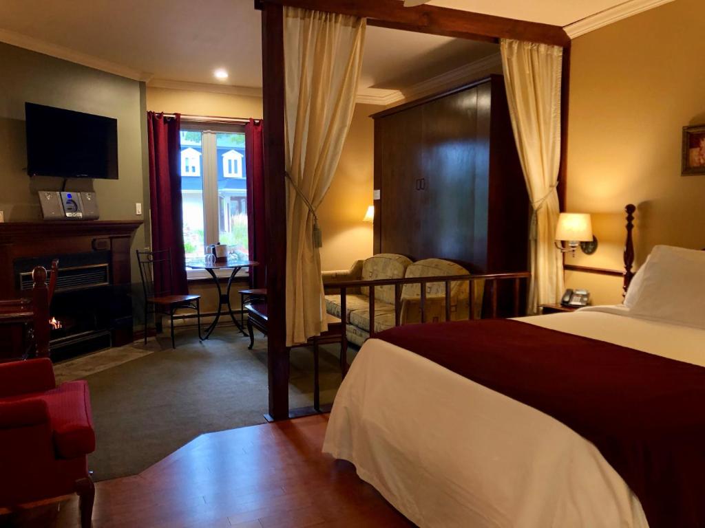a hotel room with a bed and a table and a desk at Relais St-Denis in Saint-Sauveur-des-Monts