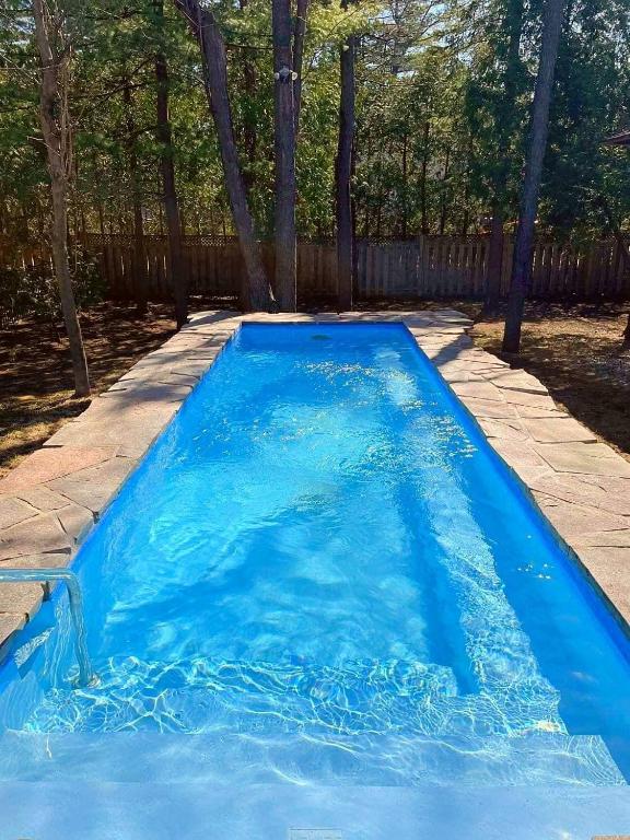a large blue swimming pool in a yard at Relais St-Denis in Saint-Sauveur-des-Monts