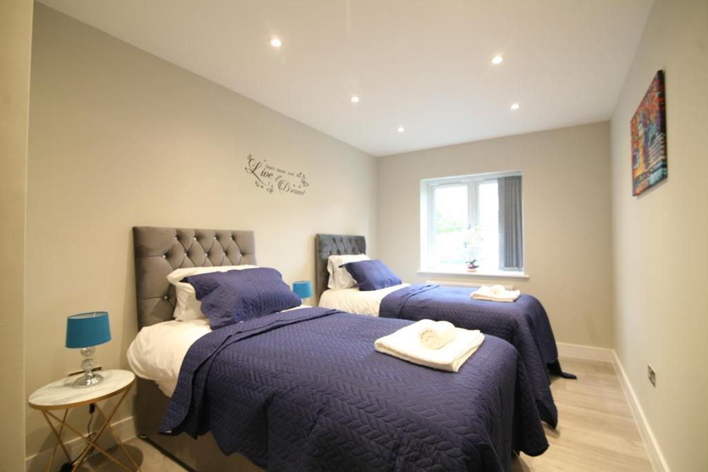 a bedroom with two beds and a window at NEW - Stylish 2 bed, Farnham Common in Hedgerley