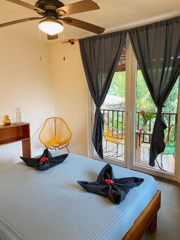 2 toallas en una cama en una habitación con ventana en Tortuguero Casa Pelican, en Tortuguero