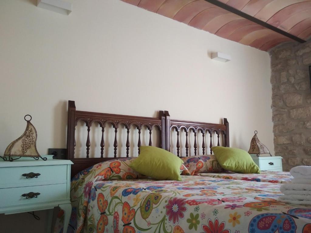 Un dormitorio con una cama con almohadas verdes. en VITORETXEA casa rural AGUILAR DE CODES, en Aguilar de Codés