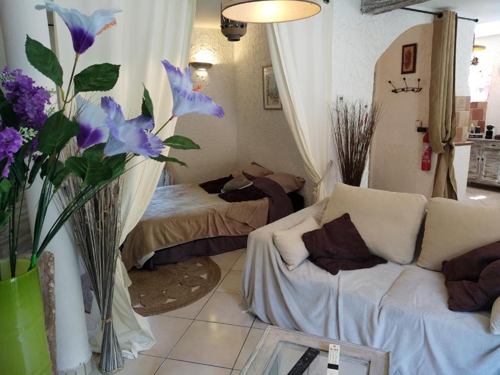 a living room with a couch and purple flowers at Le Gîte de la Tinée in Clans