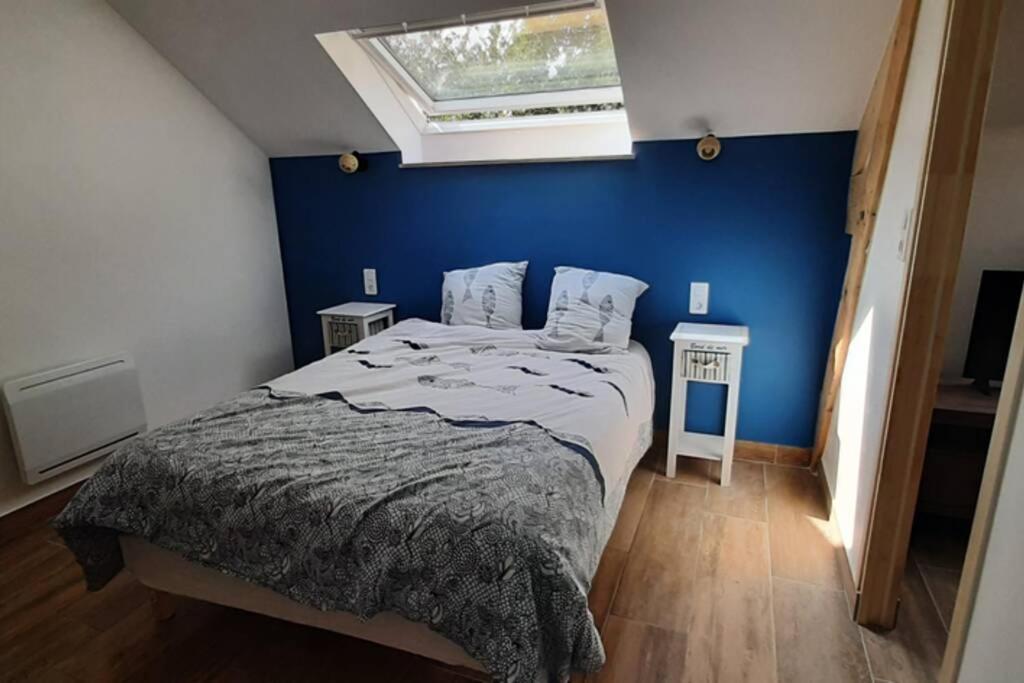 une chambre avec un grand lit avec un mur bleu dans l'établissement 16Bis 1ch, 2-4pers, jardin Les Gîtes Bigoudens, à Plonéour-Lanvern
