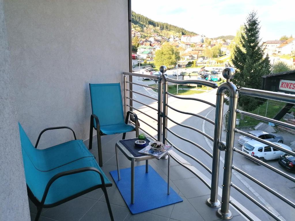 Duas cadeiras e uma mesa numa varanda em Apartman Aischa em Nova Varos