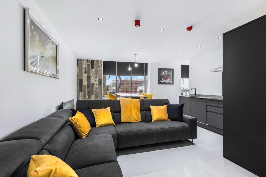 a living room with a black couch and yellow pillows at Winter Garden Apartments by Sasco in Blackpool