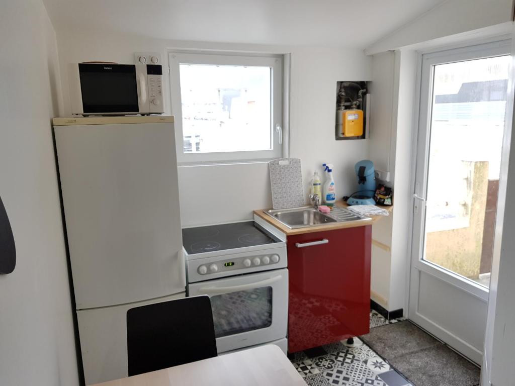eine kleine Küche mit Kühlschrank und Spüle in der Unterkunft L'Escale Penhoet in Saint-Nazaire