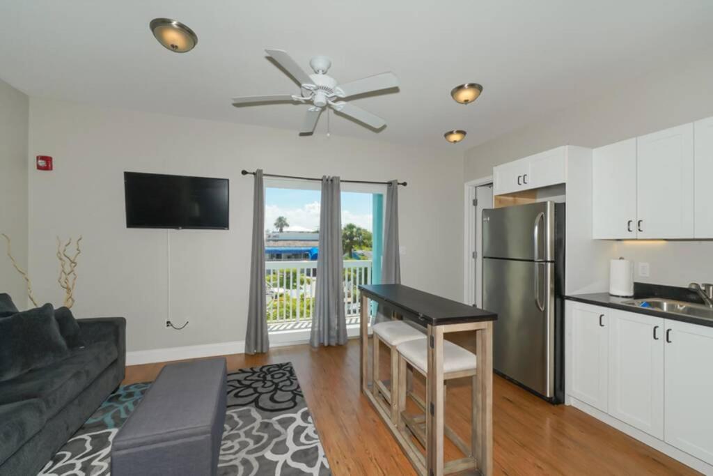 a kitchen and living room with a couch and a table at Siesta Cool: Only Minutes Walk to Siesta Beach! in Siesta Key