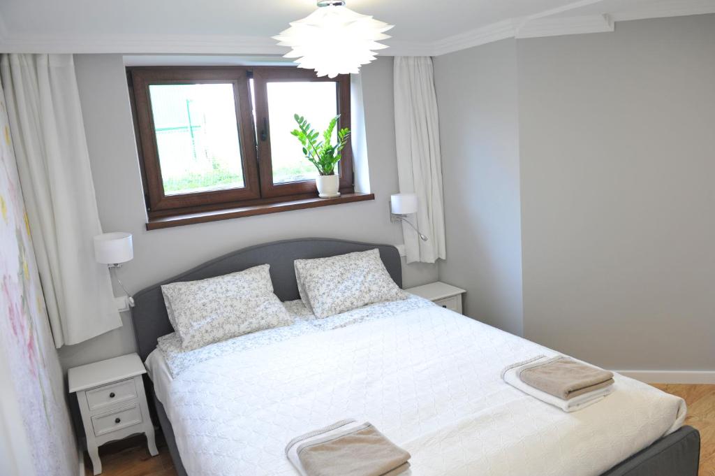 a bedroom with a white bed and a window at Apartament Bystrzyca Kłodzka in Bystrzyca Kłodzka