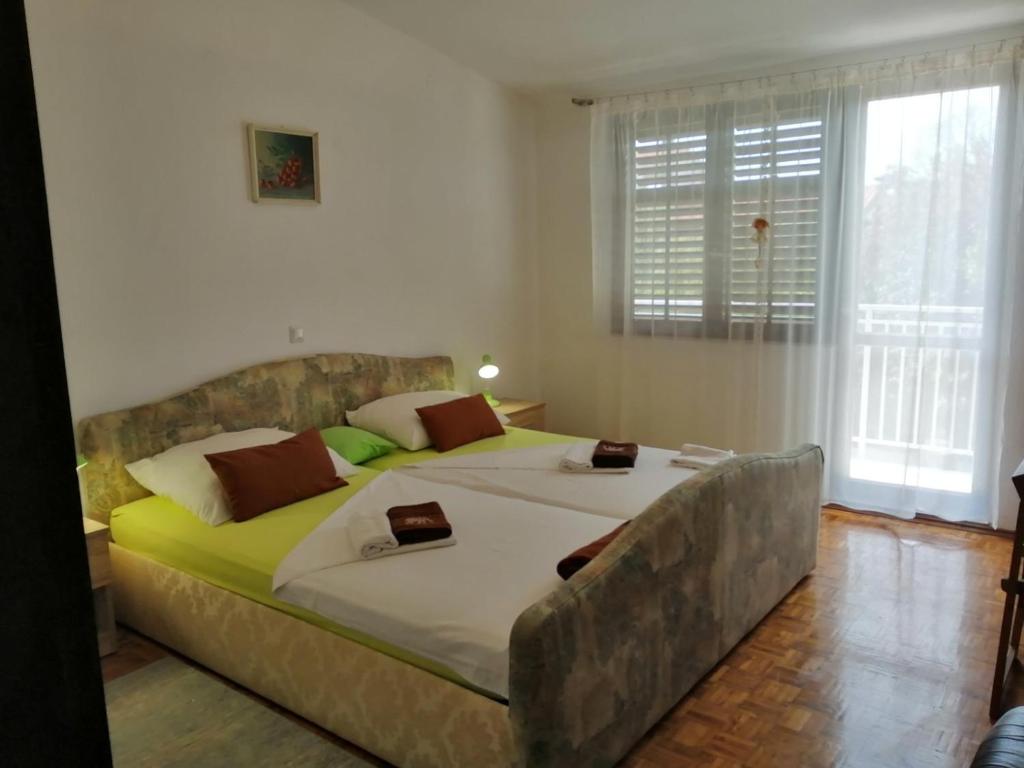 a bedroom with a large bed and a window at Apartments Kočović in Peroj