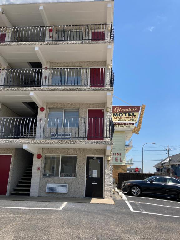 a building with a car parked in a parking lot at Glendale Motel in Seaside Heights