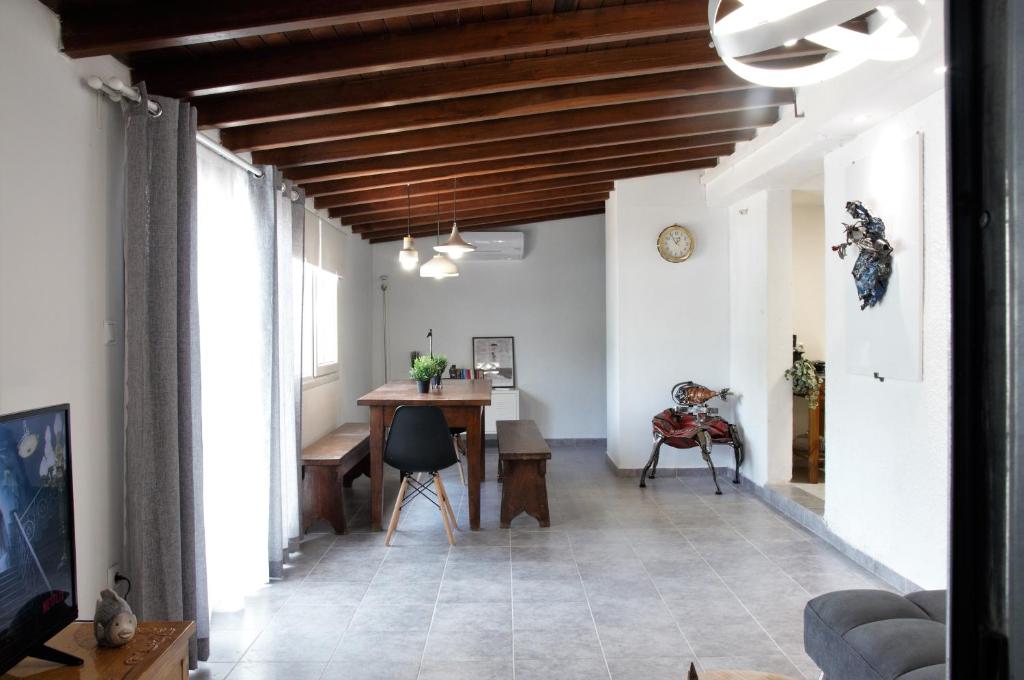 een woonkamer met een houten plafond en een tafel bij Olea House in Amoliani