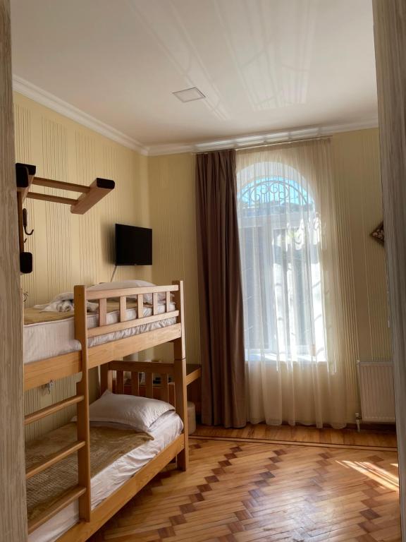 a bedroom with two bunk beds and a window at 1870 Hotel in Kutaisi