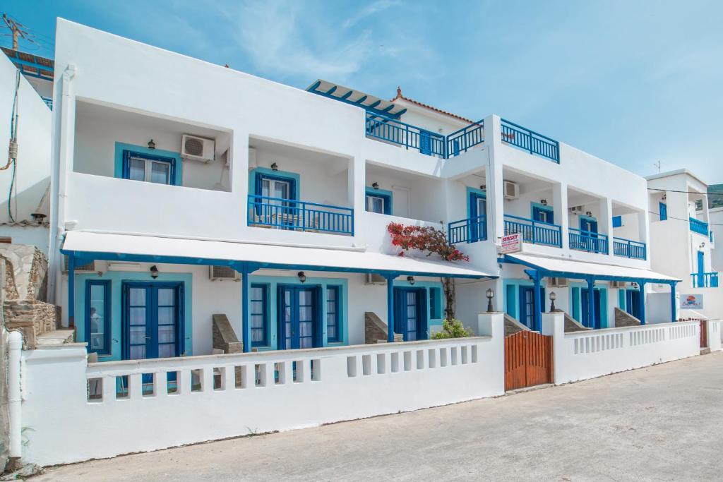 a white building with blue windows and balconies at sunsetview1 studios in Batsi