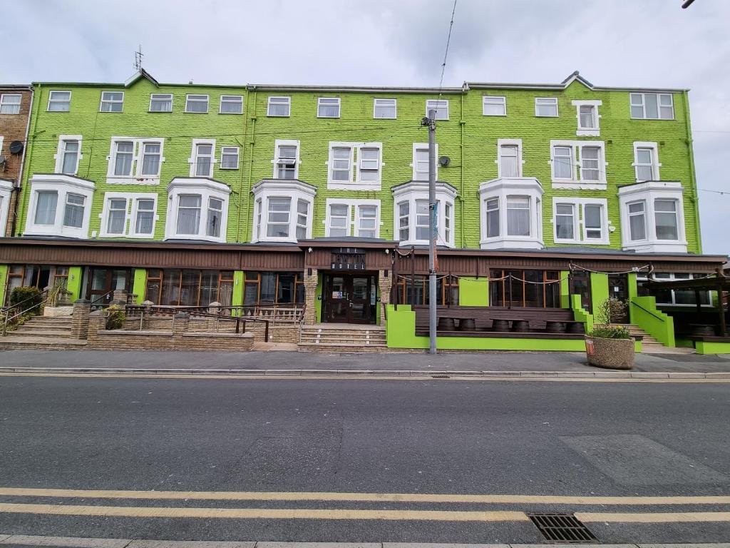 een groen gebouw met witte ramen aan een straat bij The Lawton in Blackpool
