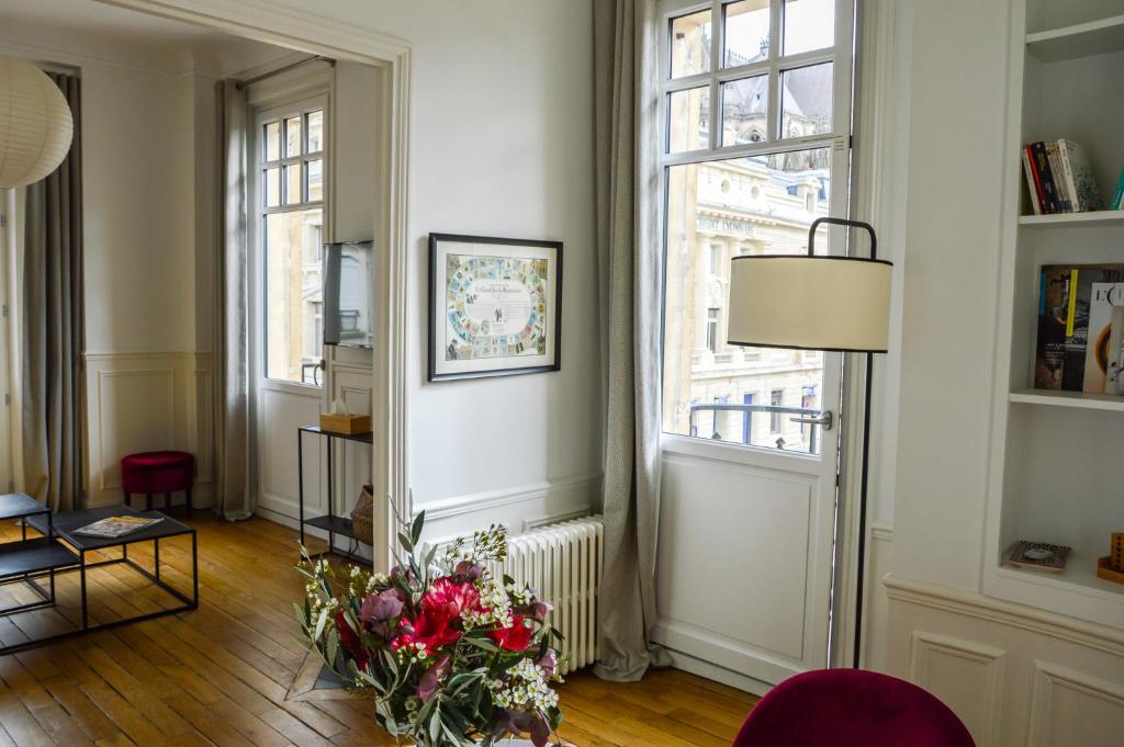uma sala de estar com um vaso de flores no chão em Les Berceaux de la Cathedrale em Reims