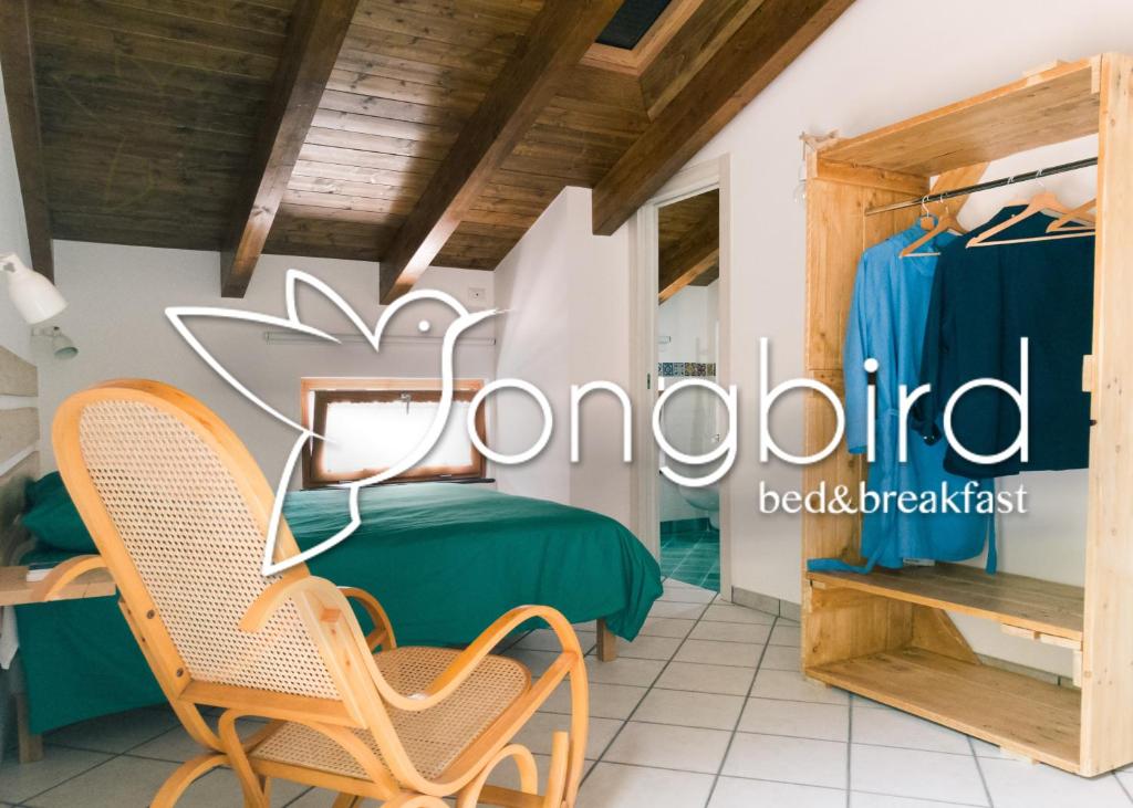 a room in a boutique with a bed and a chair at Songbird in Agerola