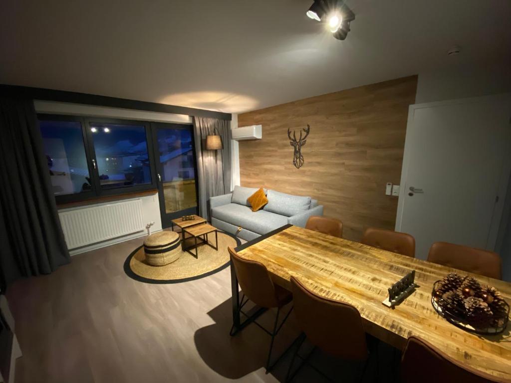 a living room with a table and a couch at Dahoam by Sarina - Village Appartements in Zell am See