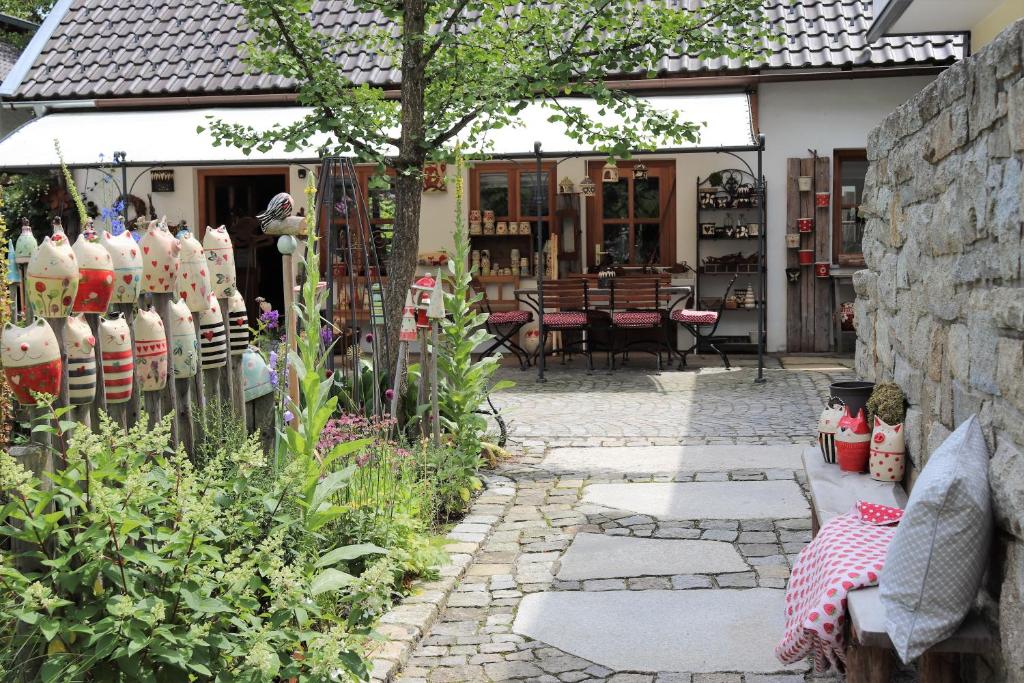 un jardin avec une passerelle en pierre en face d'un magasin dans l'établissement Schöne Ferienwohnung vor den Toren Pullman Citys zwei, à Aicha vorm Wald