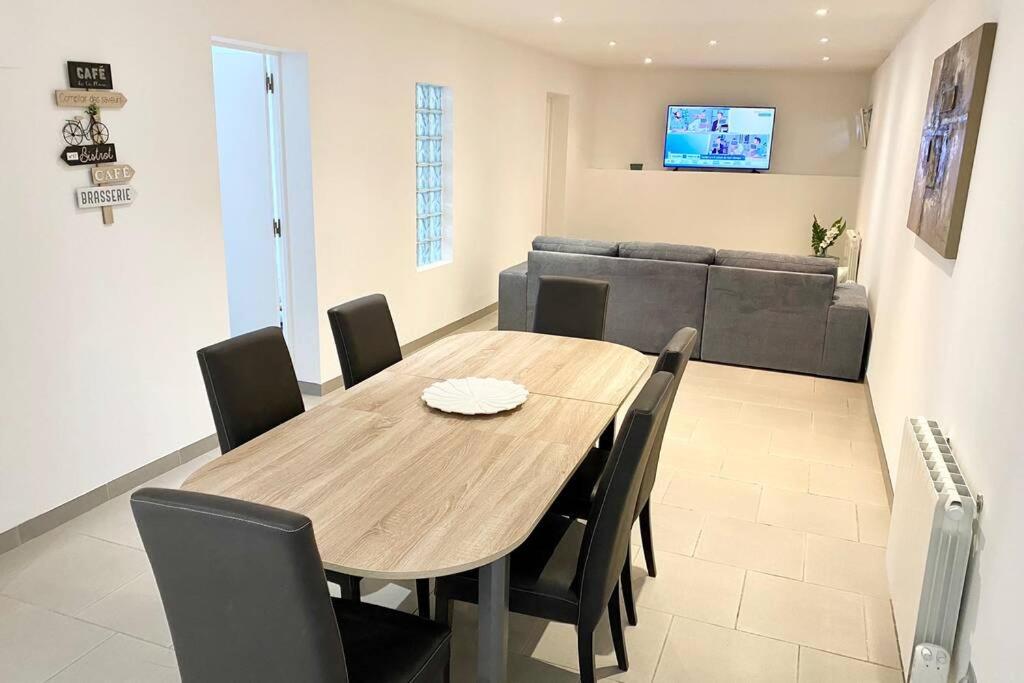 a dining room table with chairs and a couch at Le Luxueux et Spacieux in Beauvais