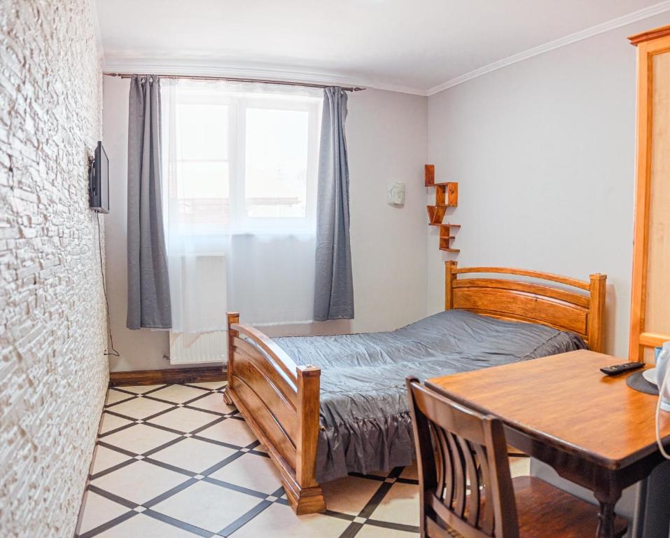 - une chambre avec un lit, une table et une fenêtre dans l'établissement SAMARIANKA hotel, à Kolomya