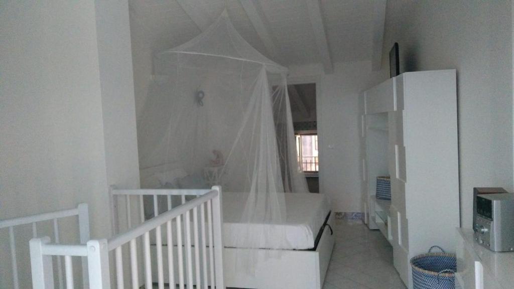 ein weißes Schlafzimmer mit einem Himmelbett in der Unterkunft Appartamento in Residence Pollio in Policastro Bussentino