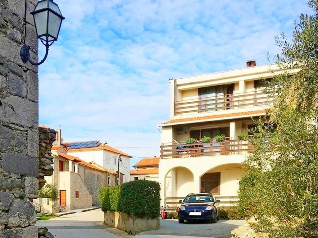 a car parked in front of a building with a balcony at Apartmani Katica in Diklo