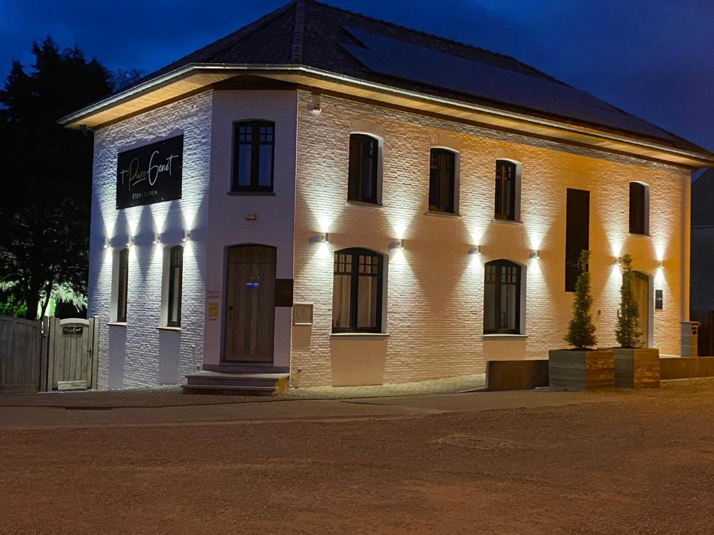 un gran edificio de ladrillo blanco con luces. en 't pure genot en Dilsen-Stokkem