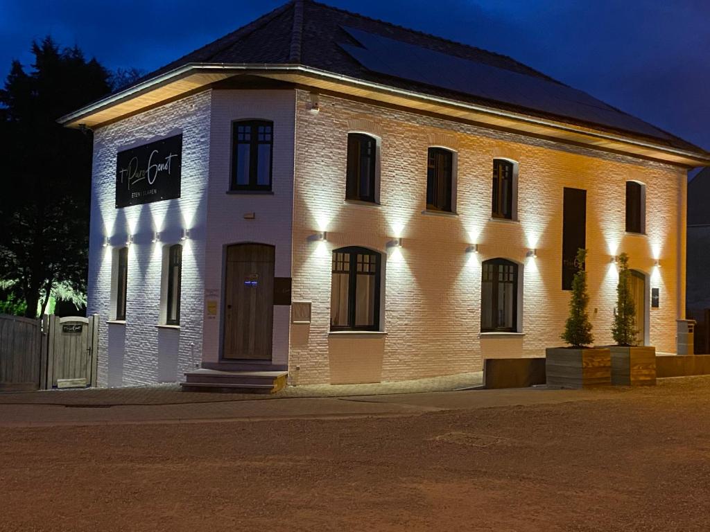 a large white brick building with lights on it at 't pure genot in Dilsen-Stokkem