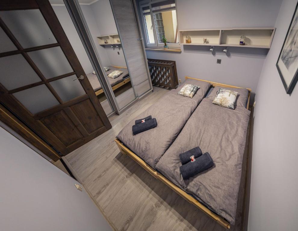 ein Schlafzimmer mit einem Bett mit zwei Kissen darauf in der Unterkunft Apartament Tuzanocuj in Duszniki-Zdrój